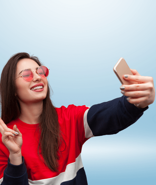 Mulher feliz tirando uma selfie em um campo de flores.