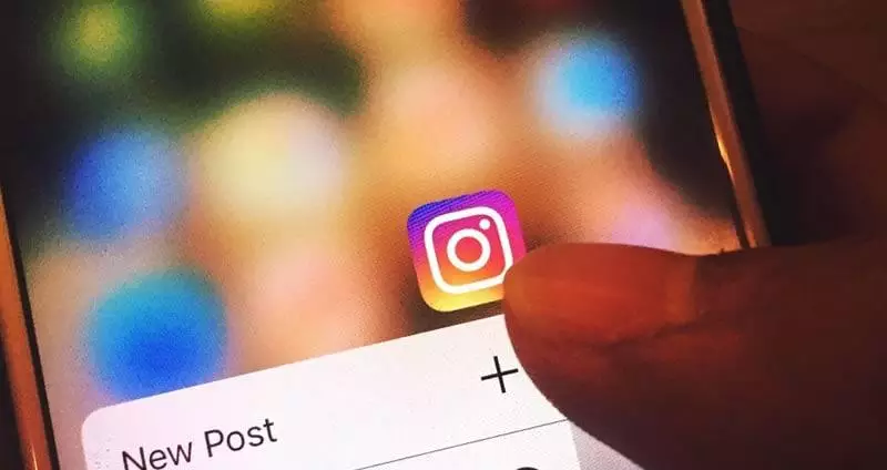 Pessoa usando o smartphone para acessar o Instagram do seu consultório odontológico.