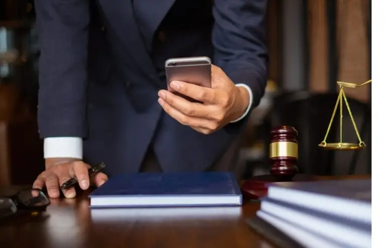 Um advogado em seu escritório, mexendo em seu celular procurando Posts para Instagram